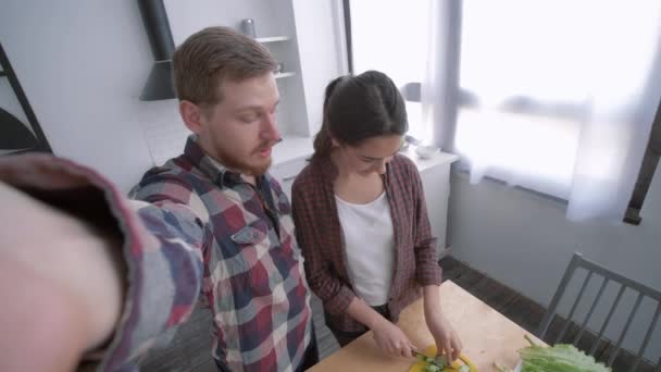 Fröhliche Familie in der Küche, junge Frau mit Mann machen Selfie-Foto mit Handy beim Kochen gesunde Ernährung aus Gemüse am Mittag für Wellness nach Ernährungsplan in der Küche — Stockvideo