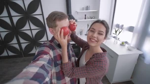 Louco homem com mulher tomar selfie vídeo no smartphone e brincando com legumes enquanto cozinha comida saudável no café da manhã para o bem-estar de acordo com o plano de dieta — Vídeo de Stock