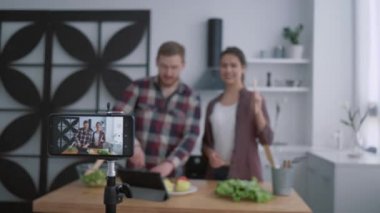 Mutfak video blogu, blog yazarları mutfakta sebzeli ve yeşillikli sağlıklı yiyecekler hazırlarken, cep telefonlu kameralar sosyal medya takipçileri için video kaydediyor.