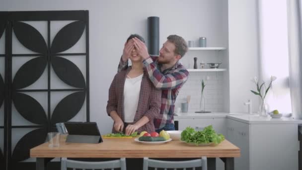 Retrato de chico feliz con chica en la cocina, mujer sonriente con hombre prepara una alimentación saludable para el almuerzo con verduras frescas en la cocina utilizando tableta con lección en línea — Vídeos de Stock