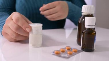 Görme engelli insanları tedavi eder, kör kadın körler alfabesi yazan hapları açar ve eline verir.