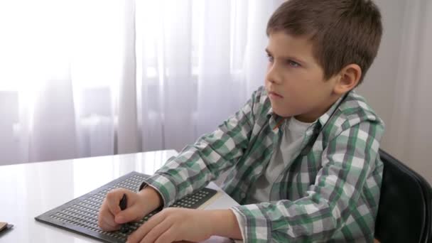 Education of Visually impaired children, blind child boy learning to write symbols font Braille sitting at table in bright — Stock Video