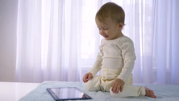 Technologies modernes dans le développement des enfants, bébé heureux agréable est joué avec la tablette dans la salle lumineuse — Video