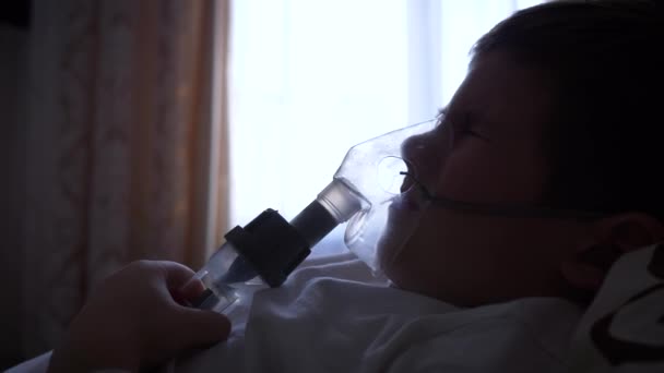 Nebulizer procedura, bolestivé dítě chlapec v masce dýchá přes inhalátor s léky na prevenci astmatu — Stock video