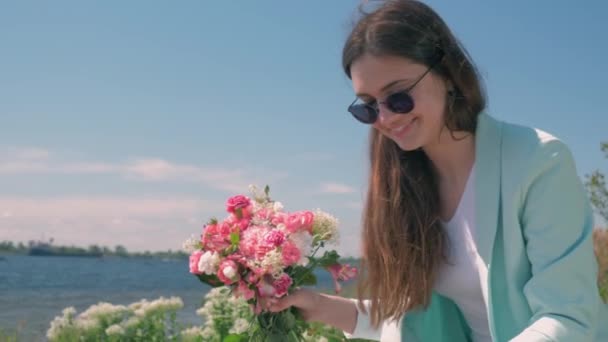 Feliz florista hembra en gafas recoge ramo de hermosas flores al aire libre — Vídeos de Stock