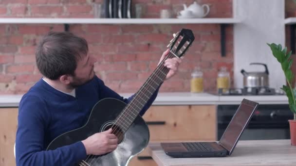 Χαρούμενα άνδρες μουσικός μαθαίνουν κιθάρα παίζει χρησιμοποιεί φορητό υπολογιστή με online διδασκαλία βίντεο και να απολαύσετε τη μουσική — Αρχείο Βίντεο