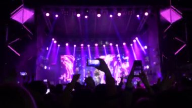 Konser partisi, cep telefonlu kalabalık gece sahne ışıkları altında rock etkinliğinde canlı müzik ve hatıra videosunun keyfini çıkarın.