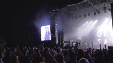 Konser partisi, kalabalık hayranları rock canlı müzik etkinliğine atlayıp el sallıyor. Gece büyük ekranlarla aydınlatılmış sahneye karşı.