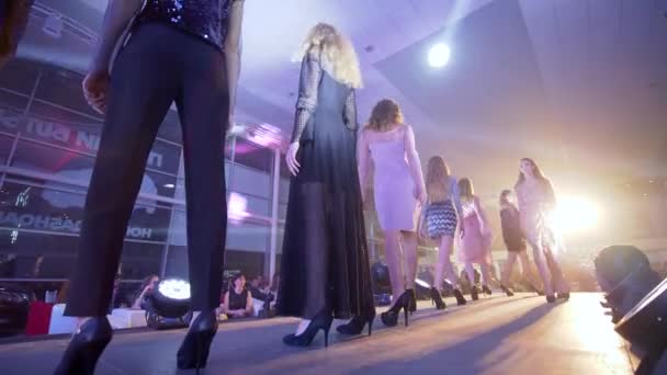 Sfilata di moda, modelle ragazze in abiti nuovi di stilista vanno in fila in passerella sotto i riflettori davanti alla gente — Video Stock