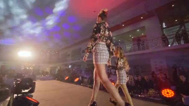 Pódio de modelo elegante com a menina ir na pista na apresentação coleção de roupas da família no desfile de moda — Vídeo de Stock