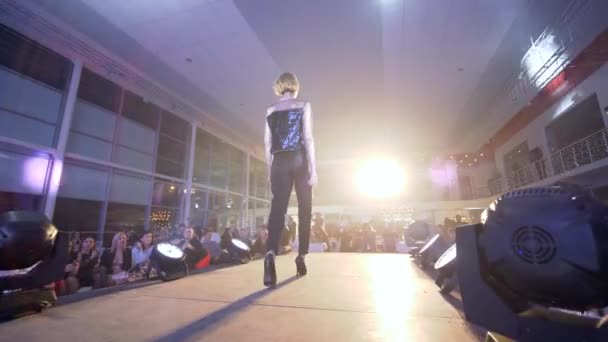 Profesionální modelka dívka na vysokých podpatcích do stylového černého obleku pošpinit na lávce na módní akce do reflektoru — Stock video