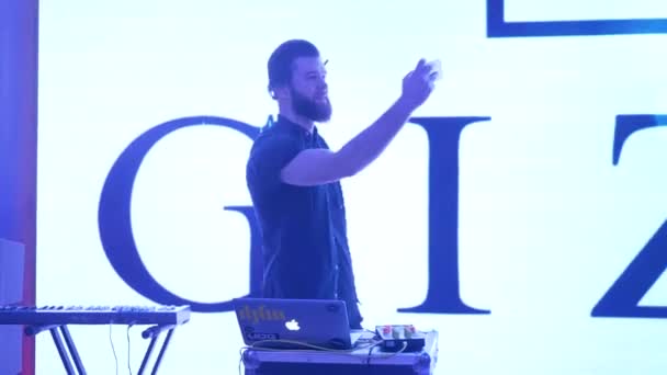 Young bearded DJ guy in headphones with smartphone makes selfie photo during work at night party with professional mixing console — Stock Video