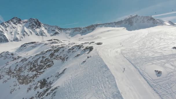 Mountain ski resort, people tourists go on snowy slope on skis and climb ski lifts against sky, drone view — Stock Video