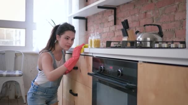 portrét šťastné ženy v domácnosti v gumových rukavicích při všeobecném čištění kuchyně a domácí práce