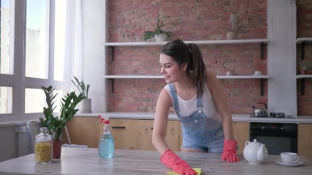 Porträtt av lycklig hushållerska flicka i gummihandskar under allmän rengöring av kök och hushållssysslor med rengöringsmedel — Stockvideo