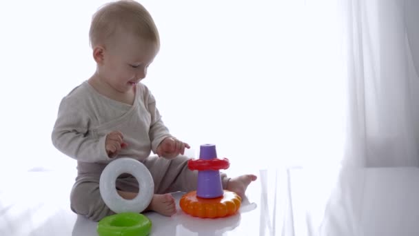 Образовательные игрушки, счастливый мальчик играет с игрушкой пирамиды дома — стоковое видео