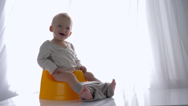 Гігієна дитини, сміється гарне дитя, сидить на камері в світлій кімнаті — стокове відео