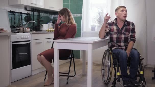 Crise familiale, relation malheureuse d'une personne handicapée dans la dépression en fauteuil roulant situation stressante avec une femme agressive hurlant et agitant les mains — Video