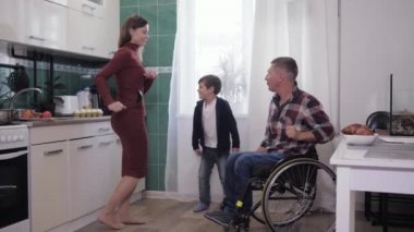 Neşeli baba, karısı ve oğluyla birlikte engelli. Mutfakta yemek pişiriyor, aile ilişkileri kuruyor.