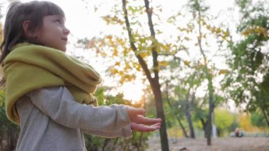 Sevimli küçük kız ellerini parkta yıkıyor ve gün batımında gülümsüyor