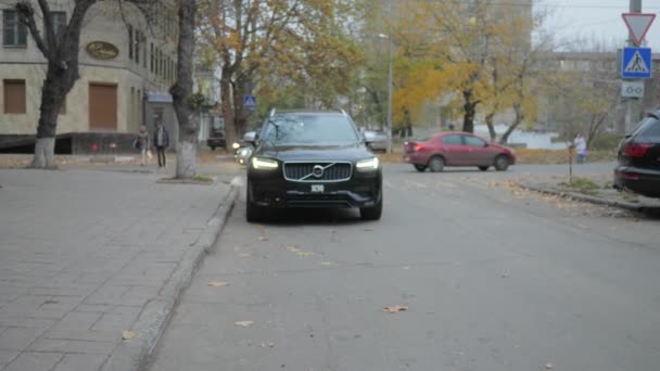 Vacker bil med brinnande ljus går ner gatan på hösten — Stockvideo