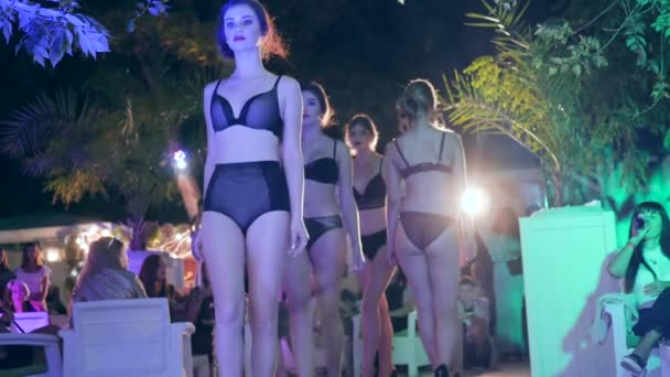 Groupe de modèles professionnels en sous-vêtements aller dans la rangée sur fond de vacances les gens en soirée En plein air — Video