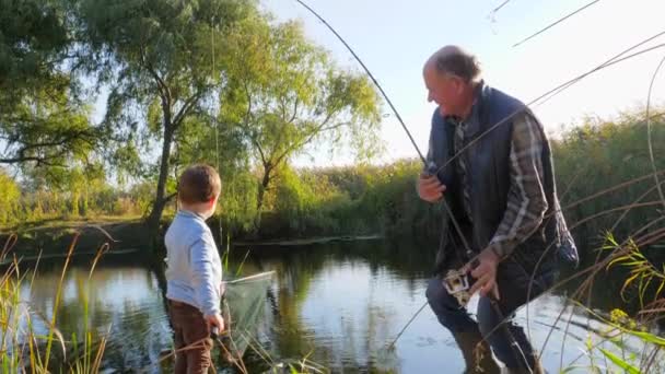 Vårfiske på sjön, farfar med sonson har god tid utomhus — Stockvideo