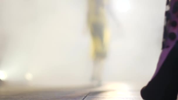 Фут моделей крупным планом, женщины ходят по подиуму на размытом фоне в дым — стоковое видео