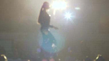 Podyumda parlak siyah şık elbiseler içinde ince bir manken, moda işi.