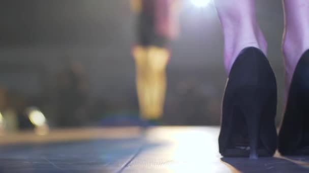 Elegant händelse, modeller på höga klackar går längs catwalk på ofokuserad bakgrund — Stockvideo