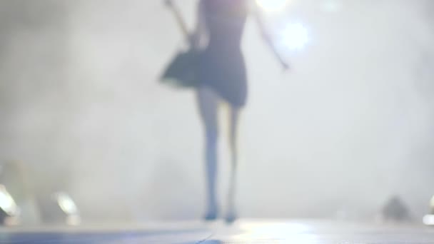 Silhuett av smal modell i snygga skor gå längs catwalk i rök på modevisning — Stockvideo