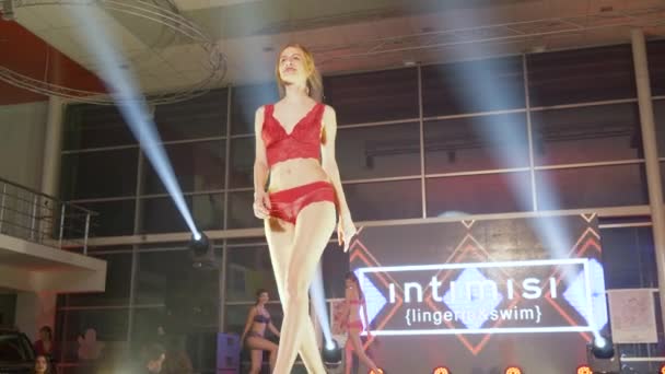 Sexy girls in lace underwear and high-heeled shoes on large illuminated stage at fashion show — ストック動画