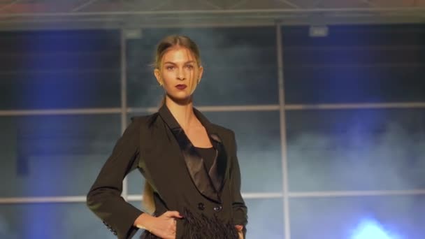 Semana de moda, modelo lindo caminha junto no pódio em vestido preto e saltos altos — Vídeo de Stock