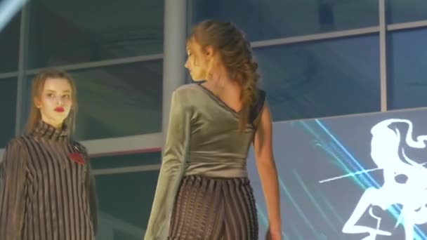 Fashionabla händelse med en akrobat på pallen, modeller i en ny kollektion kläder promenader längs på catwalk — Stockvideo