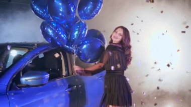 Puslu bir arabada uçan parlak süslemeler arasında dans eden kadın.