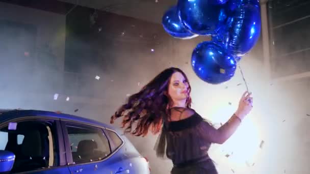 Fêmea feliz com balões infláveis na mão dançando no estacionamento do carro na névoa — Vídeo de Stock
