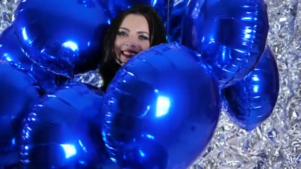 Glückliche emotionale Frauen mit blauen Luftballons auf Hintergrund glänzende Wand mit Folie dekoriert — Stockvideo