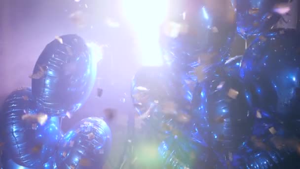 Muitos balões infláveis brilhantes no ouropel de voo na luz de fundo — Vídeo de Stock