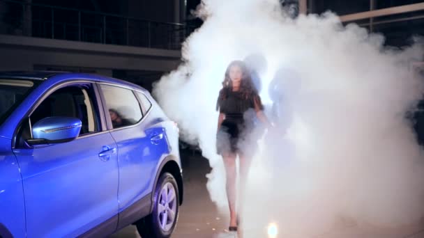 Gazdag hölgy divatos ruha felfújható léggömbök áll gép közelében füst között repülő szikrák — Stock videók