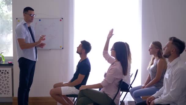 Seminerde aktif öğrenme, takım lideri sunum yapıyor ve iş arkadaşlarıyla etkileşimli eğitim hakkındaki fikirleri tartışıyor — Stok video