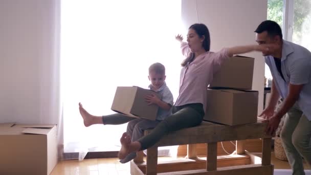 Feliz inauguración de la casa, alegres paseos familiares en la mesa en un nuevo apartamento luminoso con cajas con cosas — Vídeo de stock