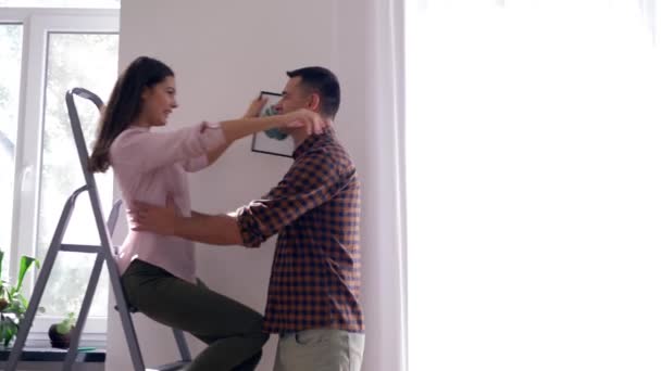 Happy relocation, man embraces and circling female in arms during home renovation to flat — Stock Video