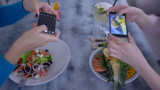 Blog yazma, modern kız arkadaşlar akıllı mobil teknolojiler kullanır ve kafede sağlıklı yemek saatlerinde sosyal ağlar için iştah açıcı yemek fotoğrafları çekerler. — Stok video
