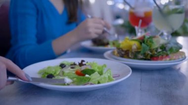 Sebze diyeti beslenme, ellerin kapalı olarak kafede yararlı bir akşam yemeği sırasında tabaktan sağlıklı salata yeme.