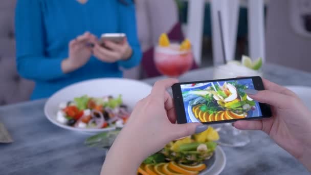 Comida saludable, las personas que utilizan el teléfono moderno para la foto de la ensalada vegetariana durante el almuerzo para las redes sociales — Vídeos de Stock