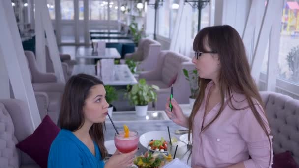 Výživa plán, mladá žena s cílem zhubnout zapisuje zdravé zeleninové stravy spolu s přítelkyní sedí v kavárně — Stock video