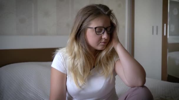 Depressziós nő problémái vannak idegesen ül a kanapén otthon, női arc szomorú kifejezés — Stock videók