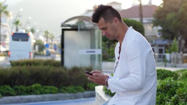 Acuerdo exitoso, hombre guapo en camisa blanca utiliza el teléfono móvil cara sorprendida en la calle — Vídeos de Stock