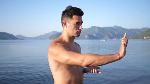 Martial arts, man on background sea is practiced self defense alone in slow motion — Stock Video