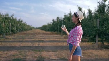 Susamış çocuk taze su içer doğada bardak, elma bahçesinde aile